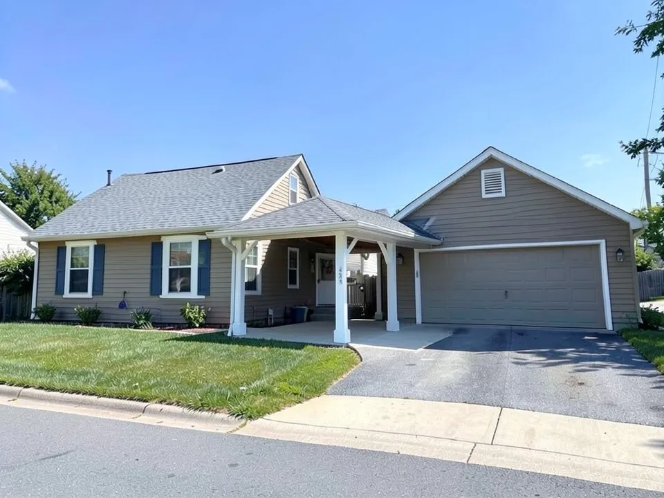 The same house and garage joined by an open breezeway with a low grey shingle gable roof on white square posts over a concrete path
