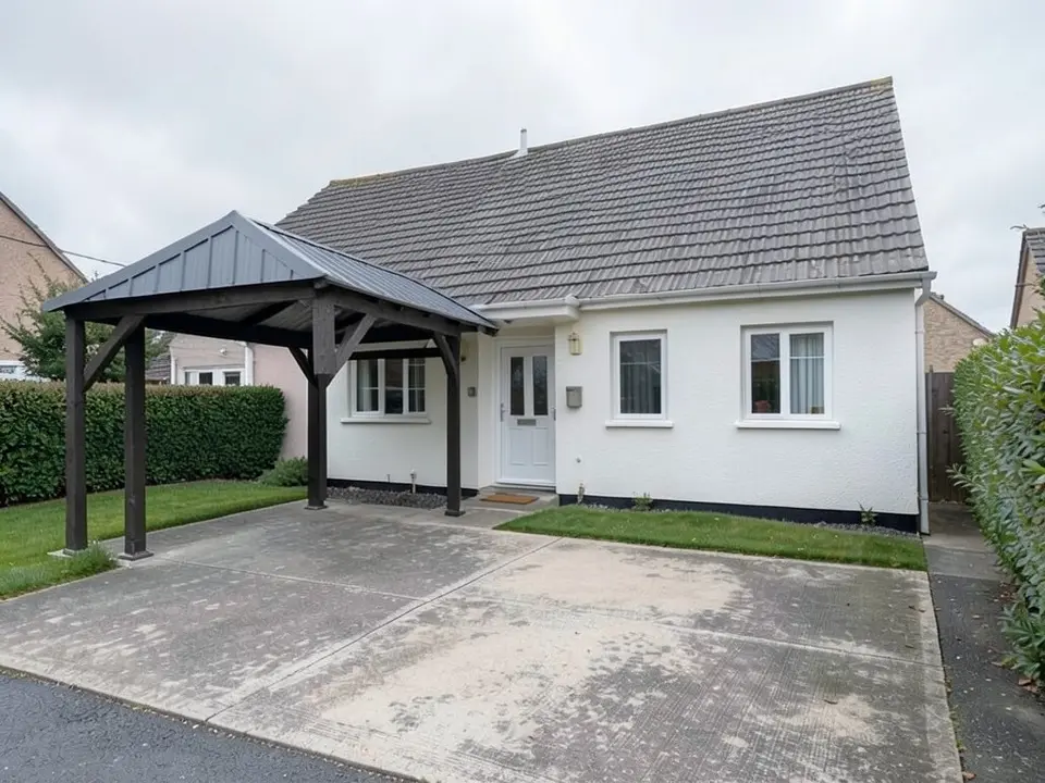 The same house with a free-standing open carport on the drive in front of its left half: four dark timber posts with diagonal braces under a dark grey metal roof with four sloping sides, with the house, door and windows behind it