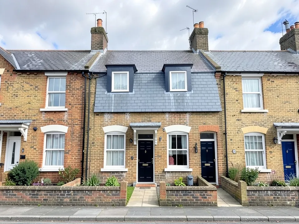 The same row where only the middle house has a new top floor in a steep grey slate mansard with two dormer windows, while the neighbours keep their low roofs